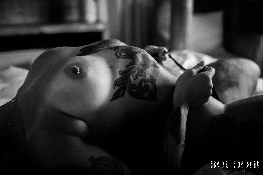 Woman with nipple piercing, torso tattoos, posing in black and white for Oahu Boudoir session