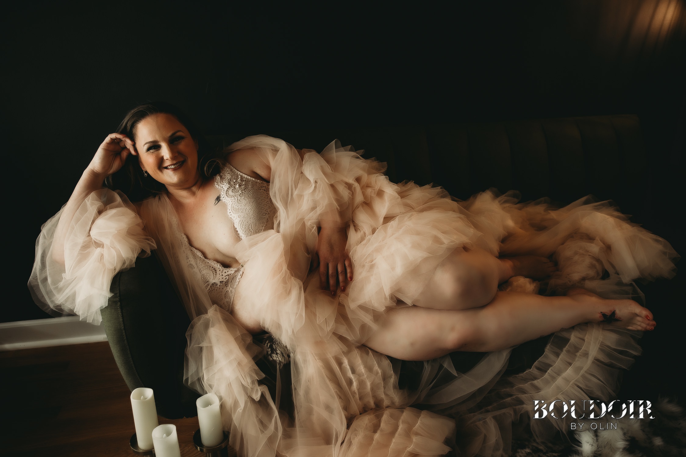 Beautiful woman in fluffy pink rob on green couch