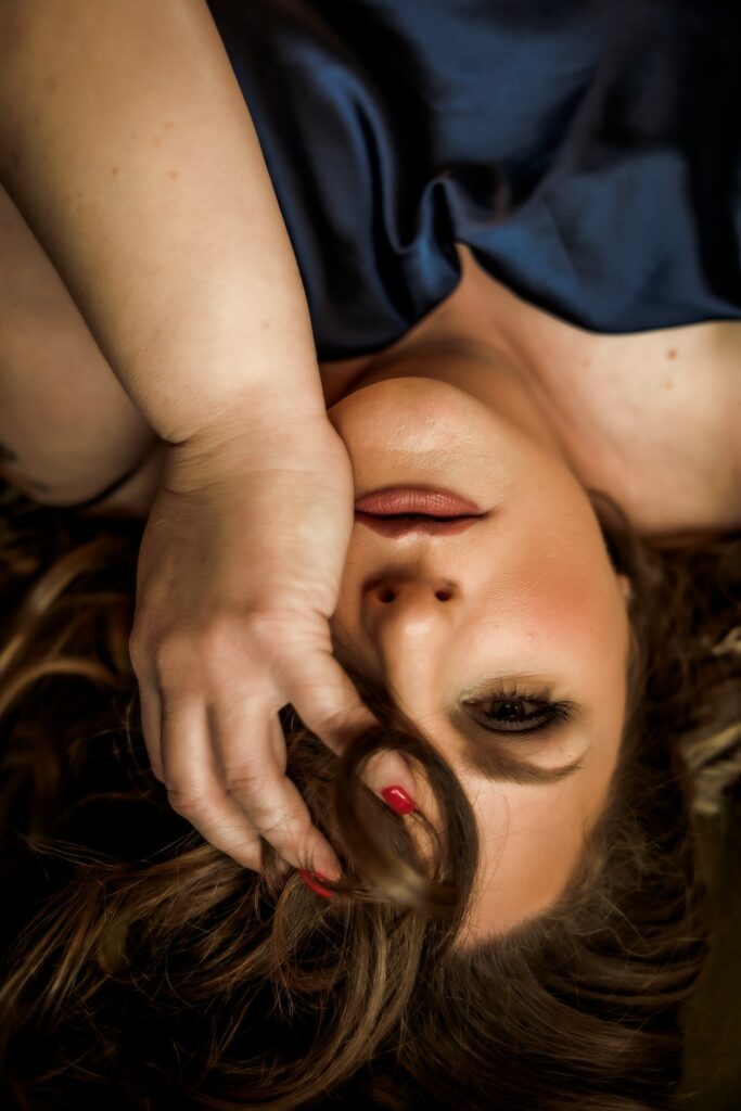 brunette woman with pink nails in navy blue nightgown