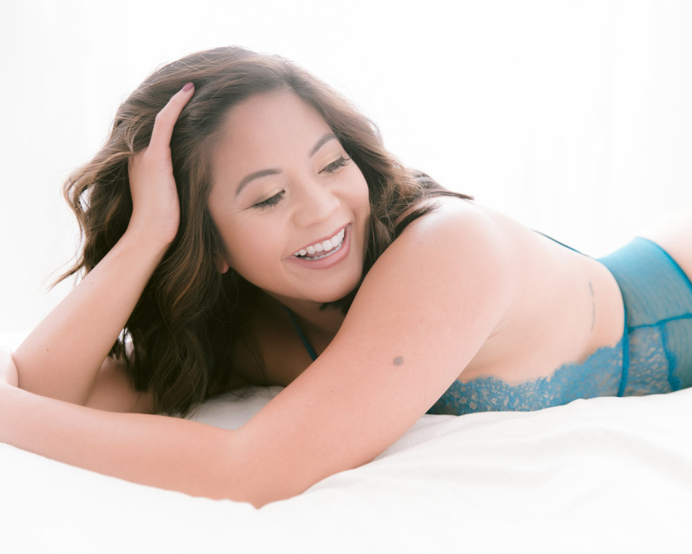 Woman laughing during a boudoir photoshoot