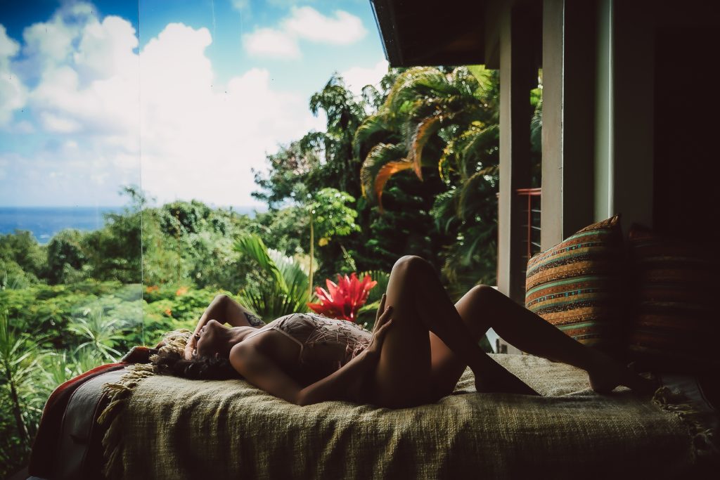 woman posing in front of tropical plants in lingerie for hawaii boudoir session