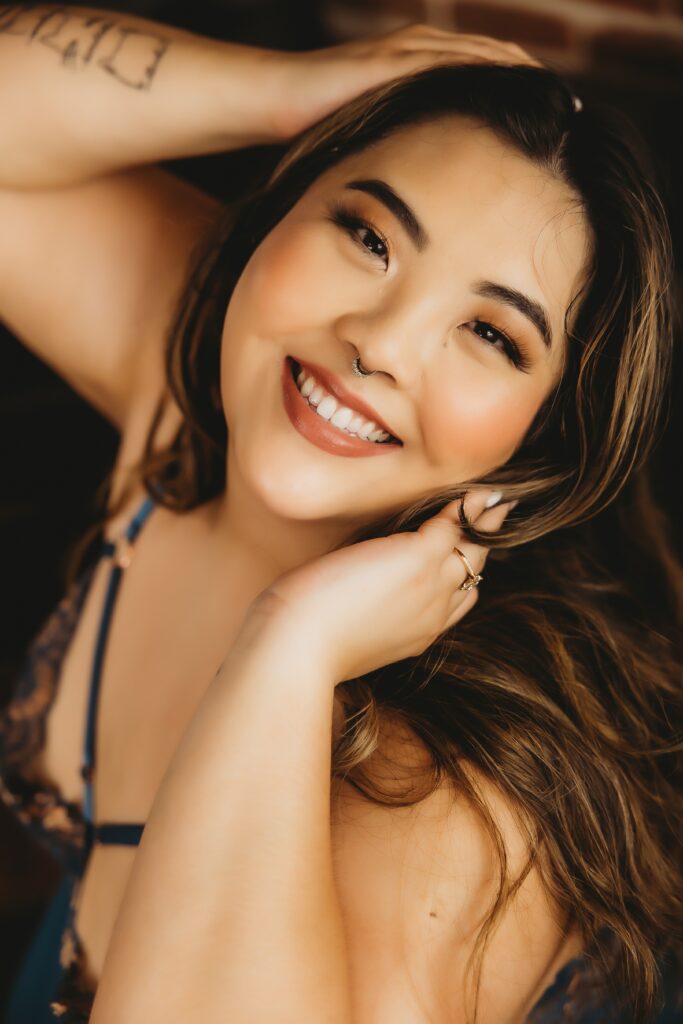 Curvy brunette smiling in blue lingerie with septum ring